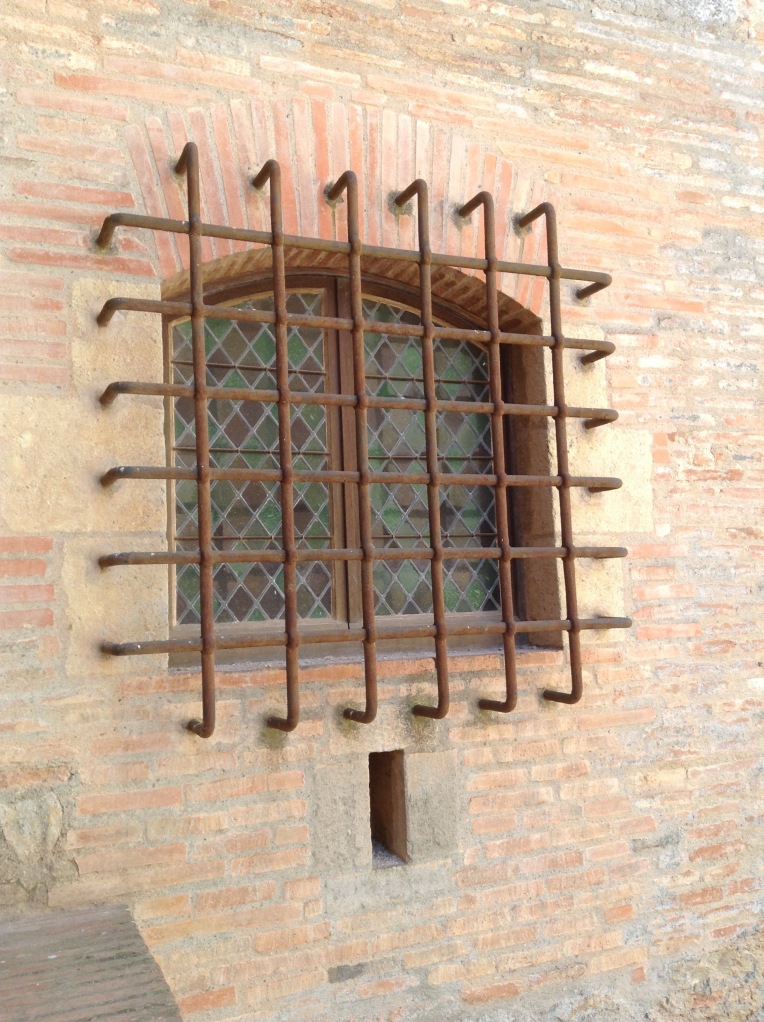 The barred, stained glass window of the governor's residence in the southwest corner of the inner keep.